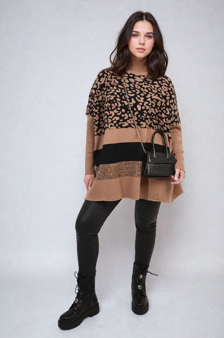 Woman wearing an Oversized Leopard Print High Neck Knitted Jumper and black pants, accessorized with a handbag and black boots, showcasing a chic, cozy look.