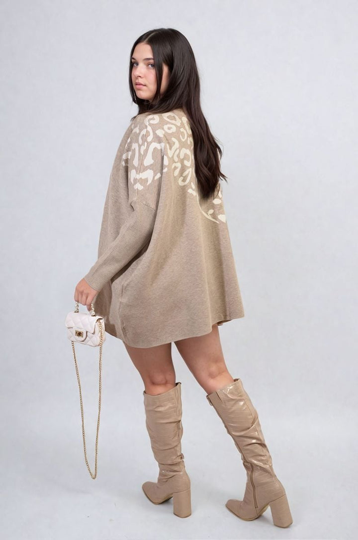 Woman wearing the Abigail Leopard Print Knitted Long Sleeve Jumper and high-heeled boots, accessorized with a gold chain pendant, showcasing chic fashion.