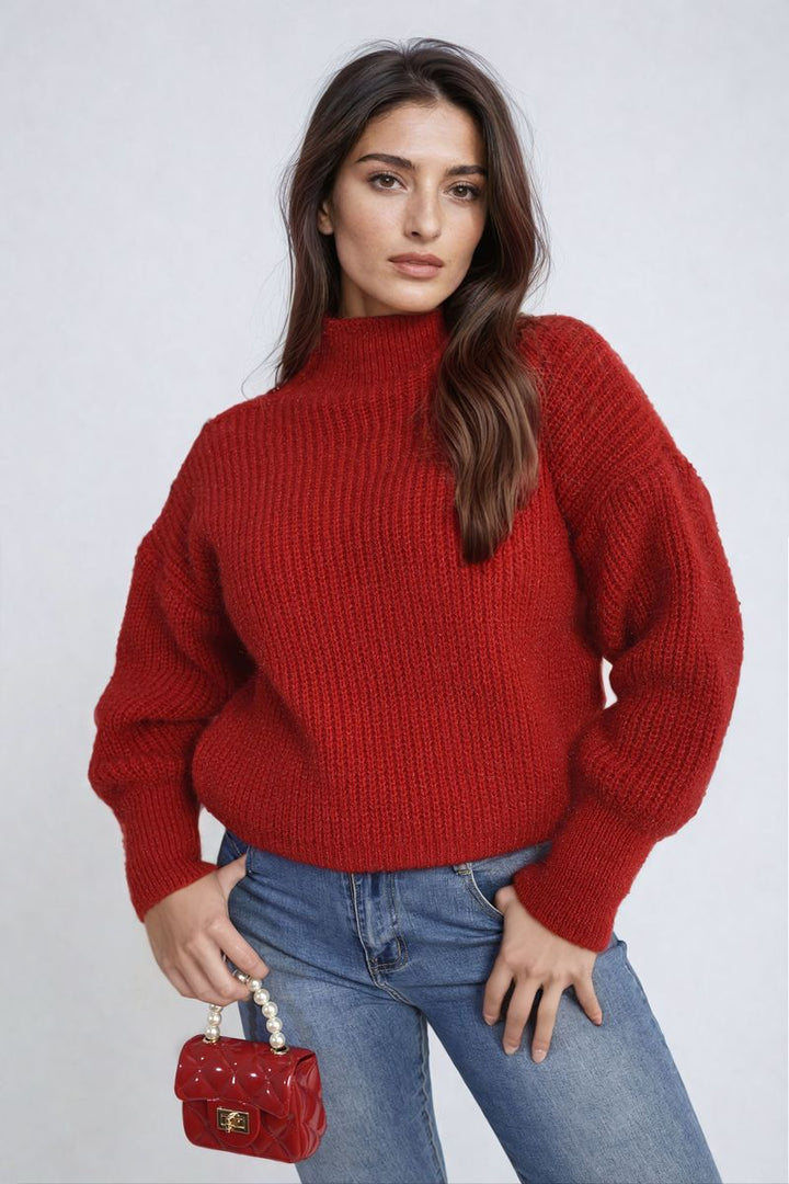 Woman wearing Alejandra Buttons Long Sleeves Chunky Knit Top, showcasing its cozy texture and button details, paired with jeans and holding a red purse.