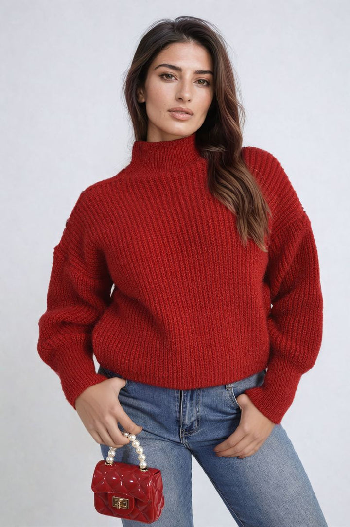 Woman in chunky knit top holds pearl necklace, showcasing the Alejandra Buttons Long Sleeves Top's cozy knit texture and stylish button details.