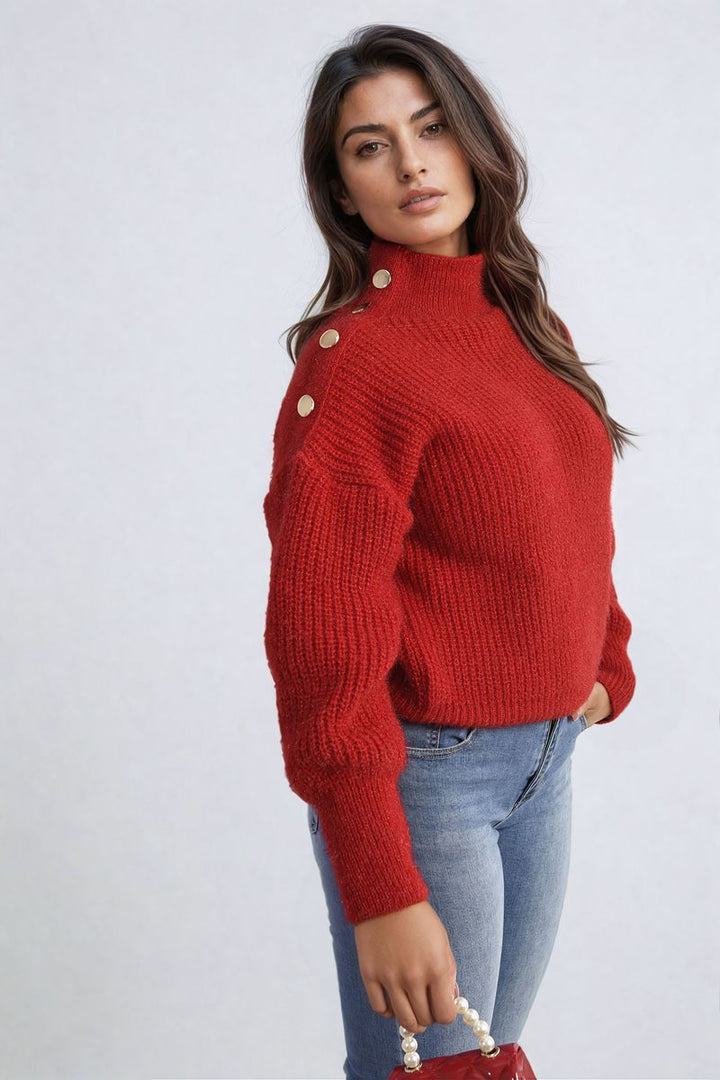 Woman wearing Alejandra Buttons Long Sleeves Chunky Knit Top, showcasing button details and chunky knit texture, holding a pearl necklace in her hand.