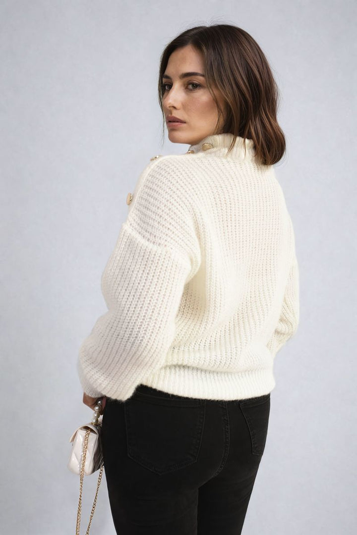 Woman in white sweater wearing the Alejandra Buttons Long Sleeves Chunky Knit Top, showcasing its cozy chunky knit texture and stylish button details.