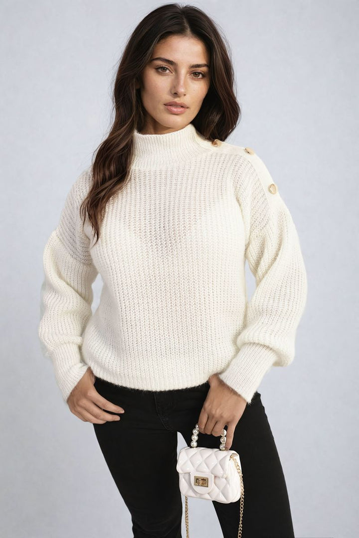 Woman wearing the Alejandra Buttons Long Sleeves Chunky Knit Top, holding a white purse, showcasing the top's chunky knit texture and button details.