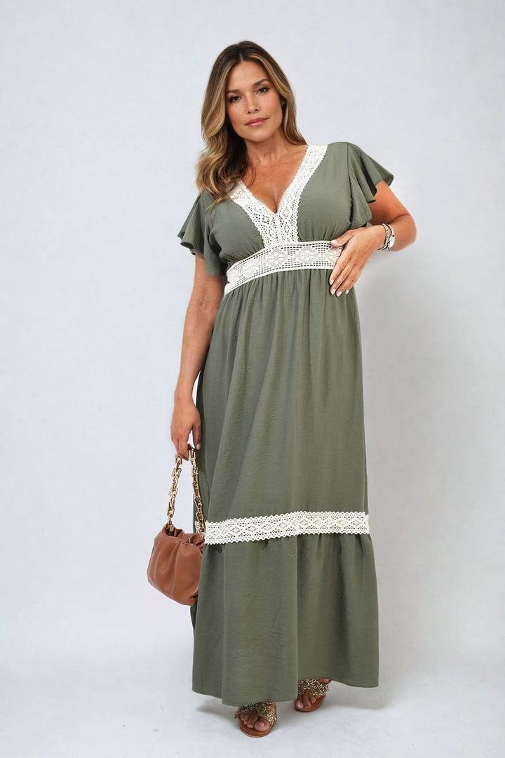 V-neck Lace Trim Maxi Dress worn by woman with gold sandals, holding brown purse. Perfect for elegant events, embodying timeless elegance and modern sophistication.