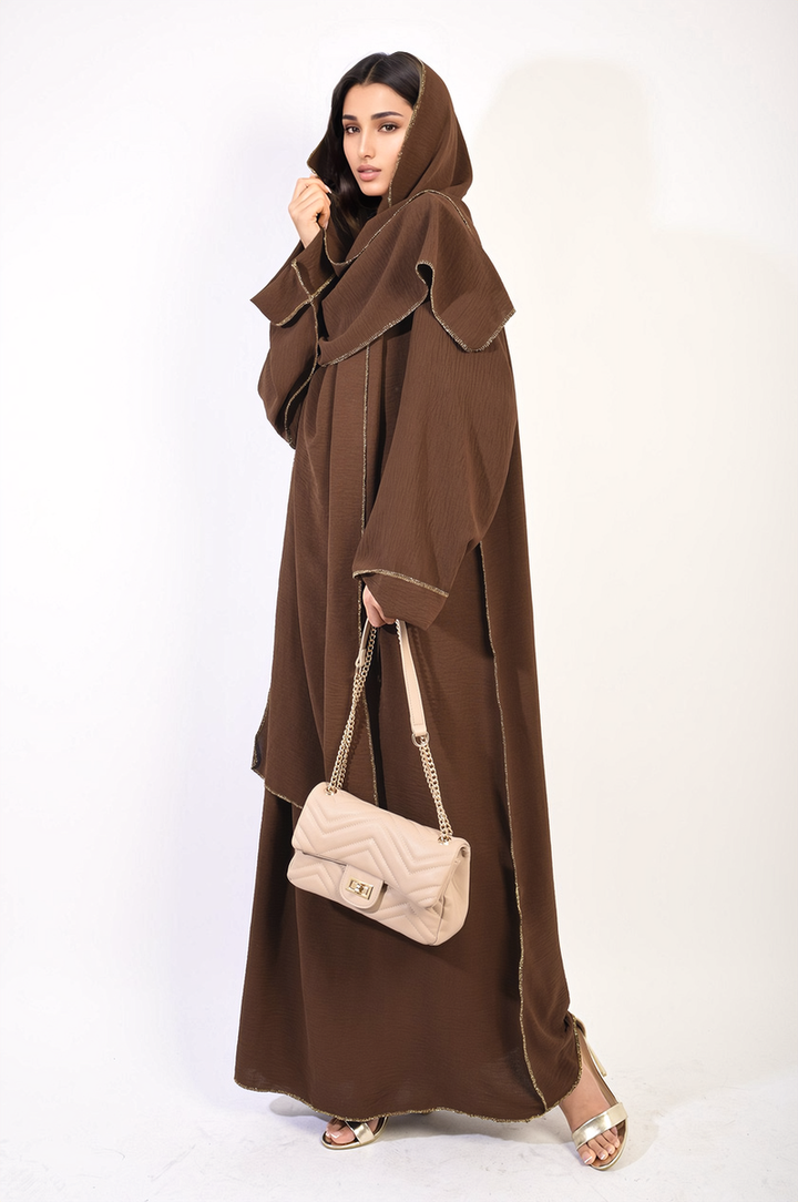 Woman in brown Long Sleeve Closed Abaya Maxi Dress with Embellished Piping, holding a handbag, showcasing modest yet stylish fashion from Holiday-Clothes.co.uk.