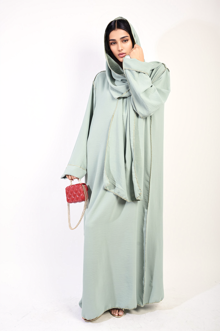 Long Sleeve Closed Abaya Maxi Dress with Embellished Piping, worn by a woman holding a red purse, showcasing its elegant and modest design.