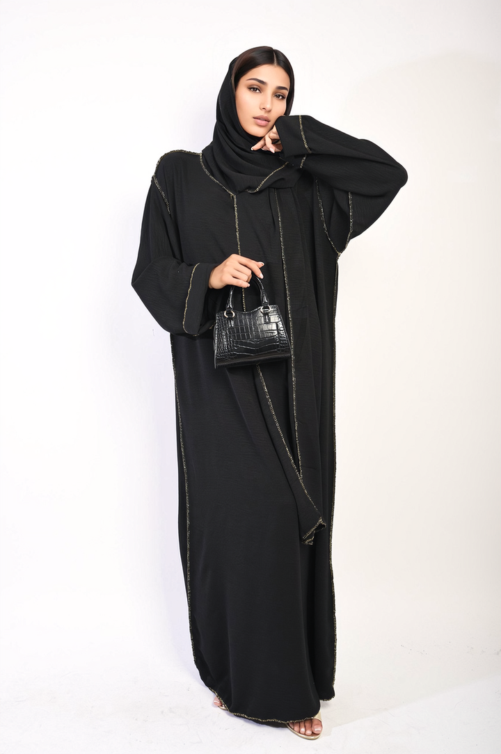 Woman in Long Sleeve Closed Abaya Maxi Dress with Embellished Piping, holding a black purse, showcasing elegant design for versatile occasions.