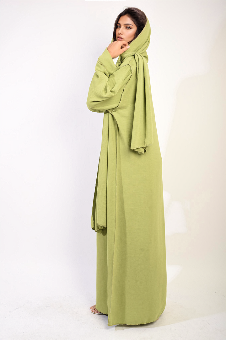 A woman models the elegant Long Sleeve Closed Abaya Maxi Dress with Embellished Piping, showcasing its draped fabric and sophisticated design.