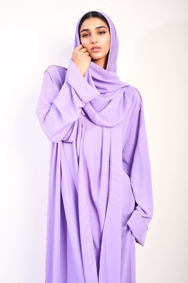 A woman models the Long Sleeve Closed Abaya Maxi Dress with Embellished Piping, showcasing its elegant design and flattering silhouette.