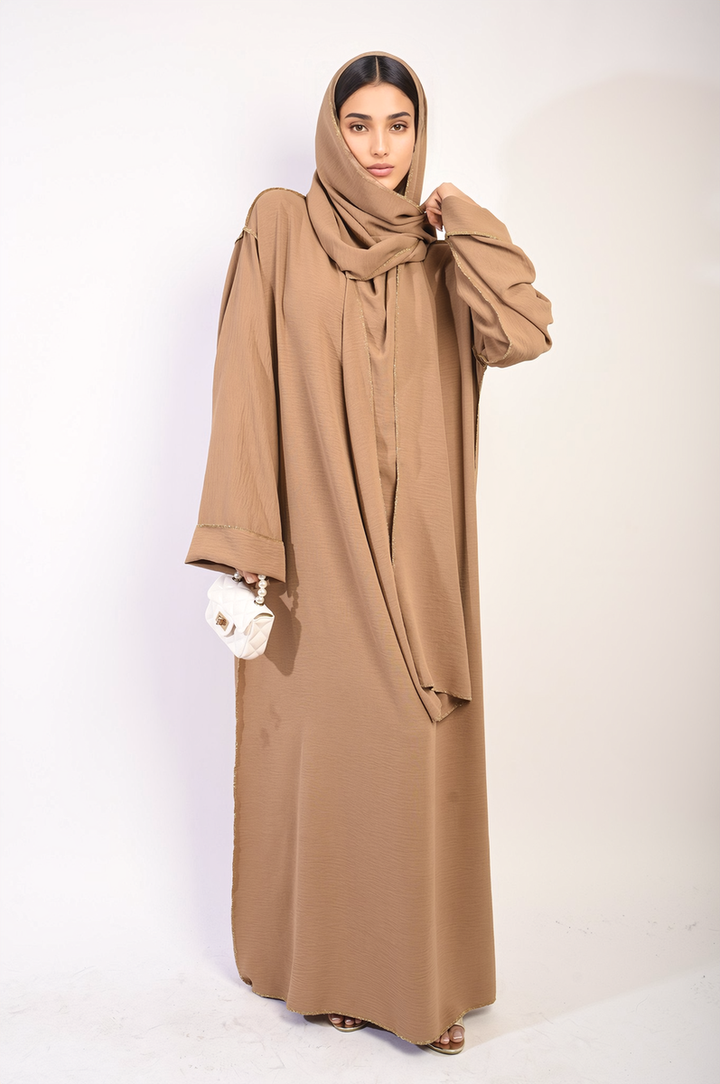 Long Sleeve Closed Abaya Maxi Dress With Embellished Piping, worn by a woman, featuring a headscarf and a white bag for added elegance.