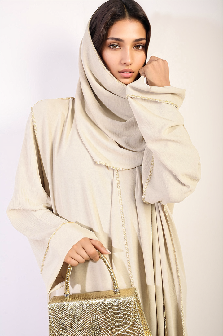 Long Sleeve Closed Abaya Maxi Dress with Embellished Piping, worn by a woman, featuring a modest design and sparkling details, complemented by a tan scarf.