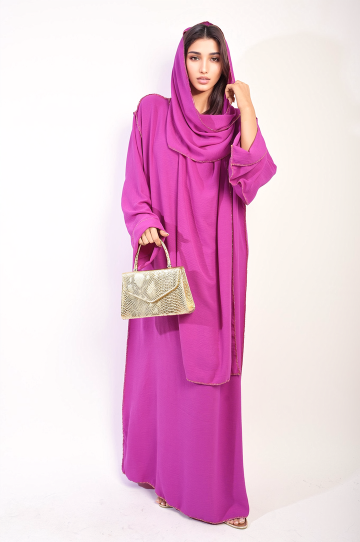 Woman in a Long Sleeve Closed Abaya Maxi Dress with Embellished Piping, styled with a matching scarf, holding a gold purse.