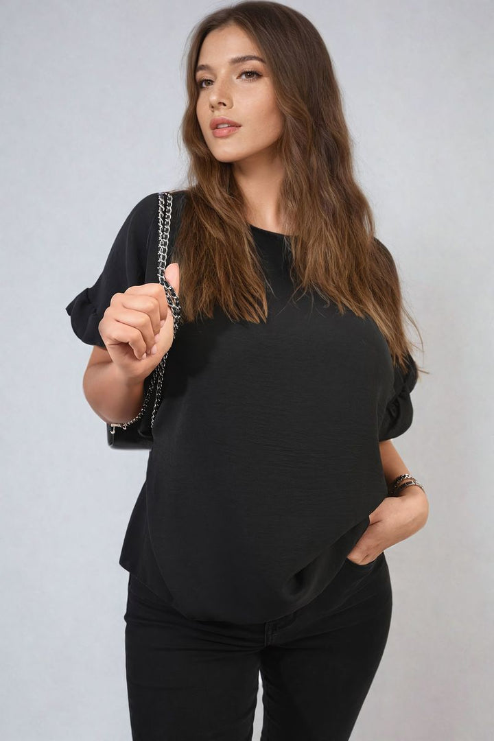 Woman wearing the Alexandra Frill Sleeve Top, showcasing its elegant frill sleeves and stylish design, perfect for versatile holiday and everyday outfits.