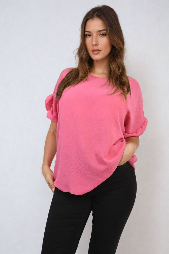 Woman wearing Alexandra Frill Sleeve Top, showcasing elegant frill sleeves and comfortable fit. Perfect for versatile styling from holiday to everyday wear.