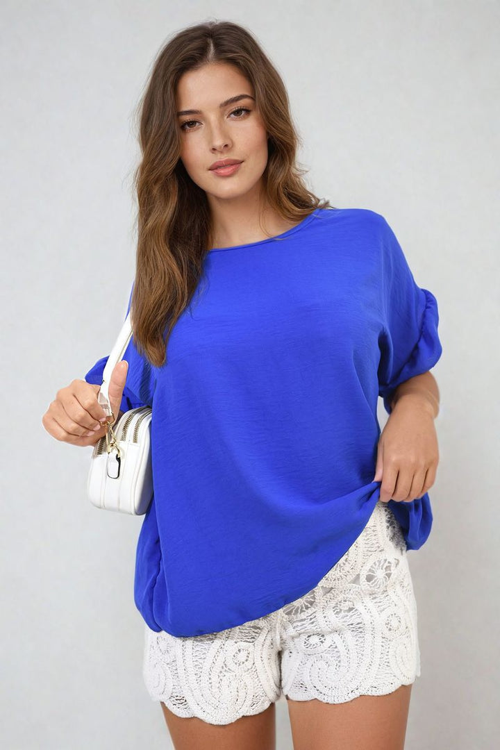 Woman wearing Frill Sleeve Top, showcasing delicate frill sleeves. Ideal for stylish versatility, perfect for both casual and elegant occasions.