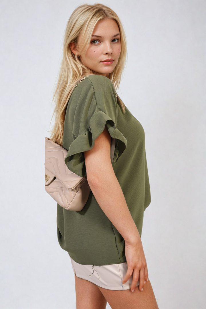 Woman models the Alexandra Frill Sleeve Top, showcasing its elegant frill sleeves and stylish design, perfect for versatile holiday or everyday wear.