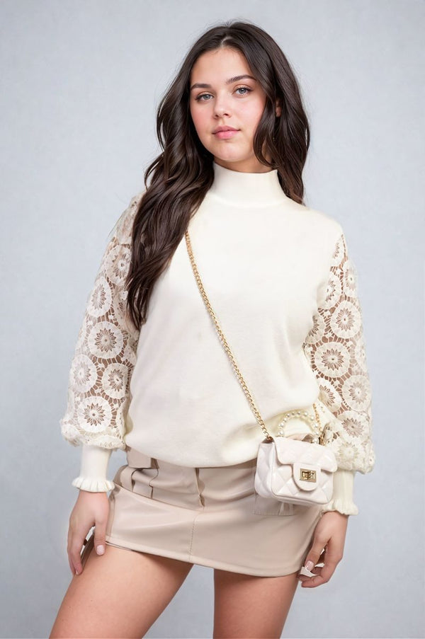 Woman modeling a stylish high neck knit jumper with crochet sleeves, perfect for a cozy, elegant look.