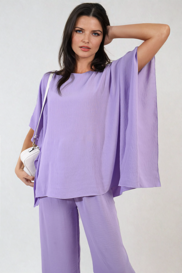 Woman wearing the Alicia Casual Oversized Top, showcasing a relaxed, stylish fit with ruffle sleeves and a V-neckline, ideal for casual occasions.