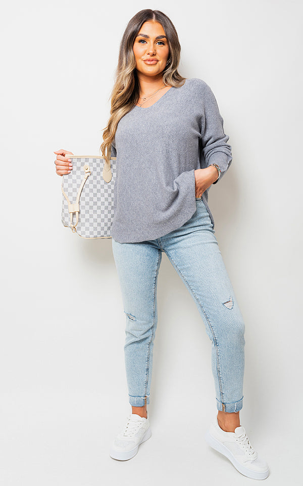 Woman holding Oversized Long Sleeve Knitted Jumper, showcasing its cozy fit and casual style, perfect for leisurely outings or cozy moments.