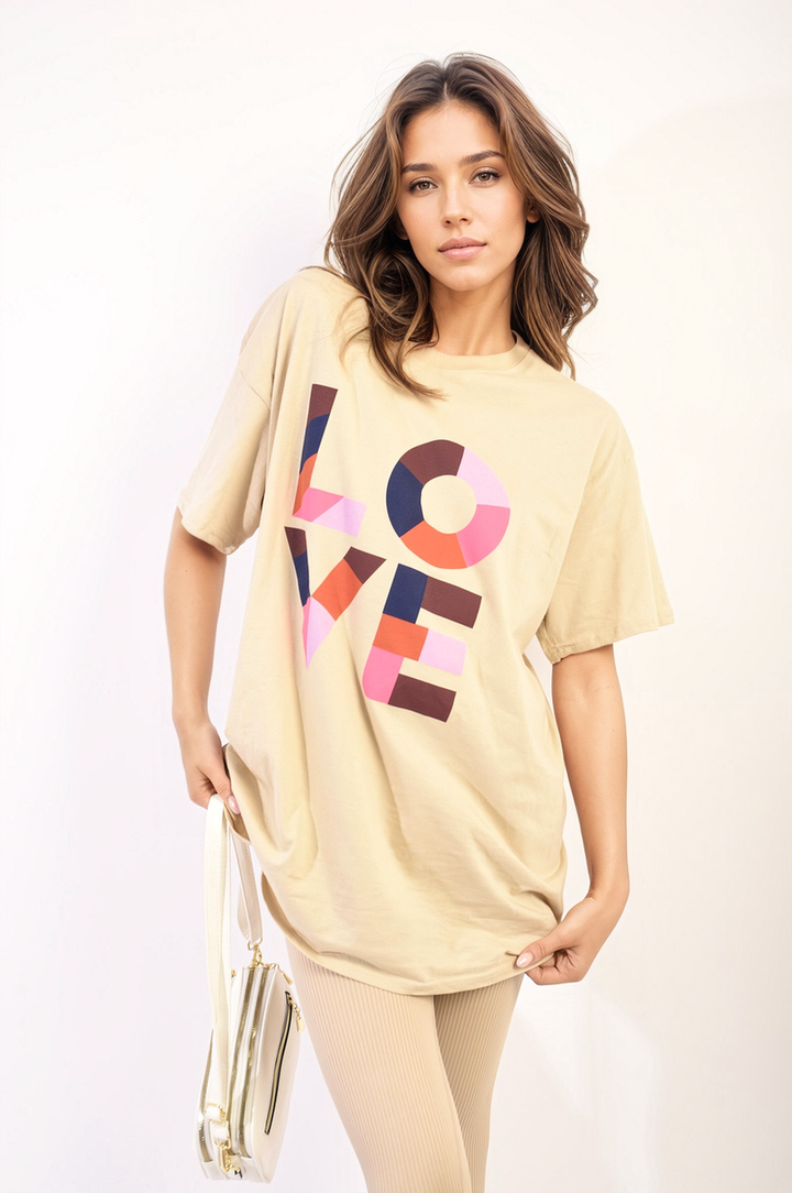 Woman wearing Amanda Oversized Love Slogan Print Top, showcasing its vibrant design and casual fit, perfectly suited for relaxed, stylish looks.