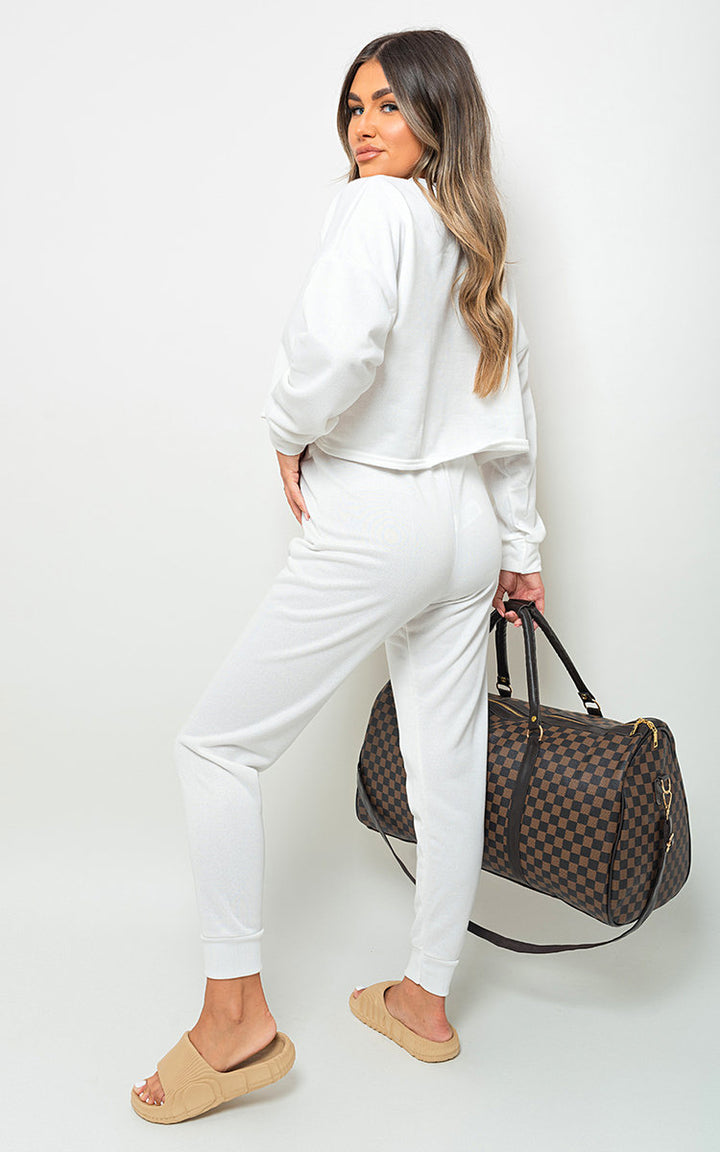 Woman in white Amanda Sweatshirt and Jogger Loungewear Co-ord Set holding a bag, showcasing comfort and style for casual outings or lounging.