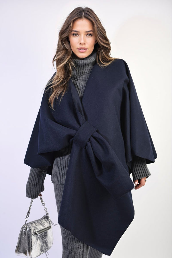 Woman wearing the Solid Batwing Sleeve Crossover Cape Coat, featuring a chic crossover design and batwing sleeves, accessorized with a silver purse.