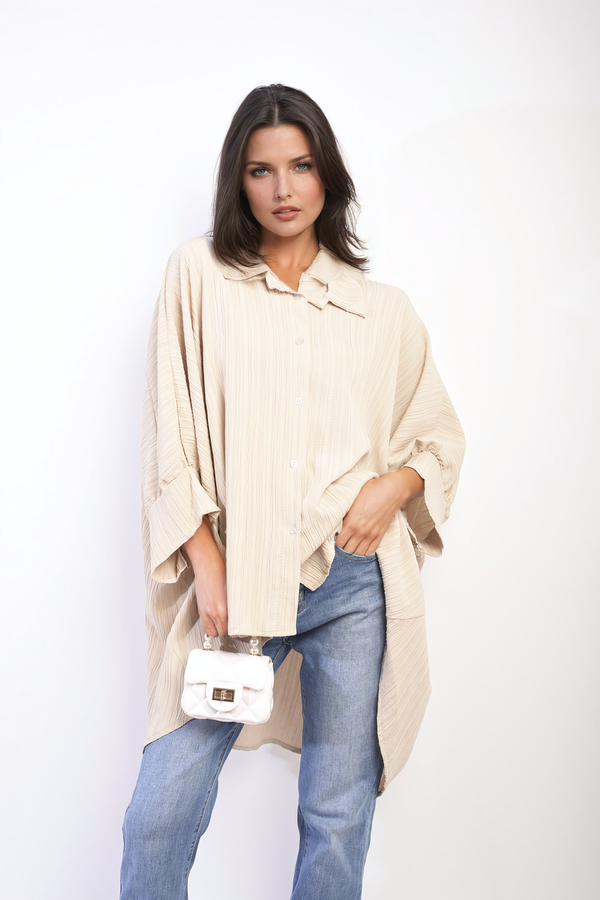 Woman wearing the Angela Oversized Long Sleeve Button Front Top, holding a white bag. Perfect for relaxed, stylish looks from Holiday Clothes UK.