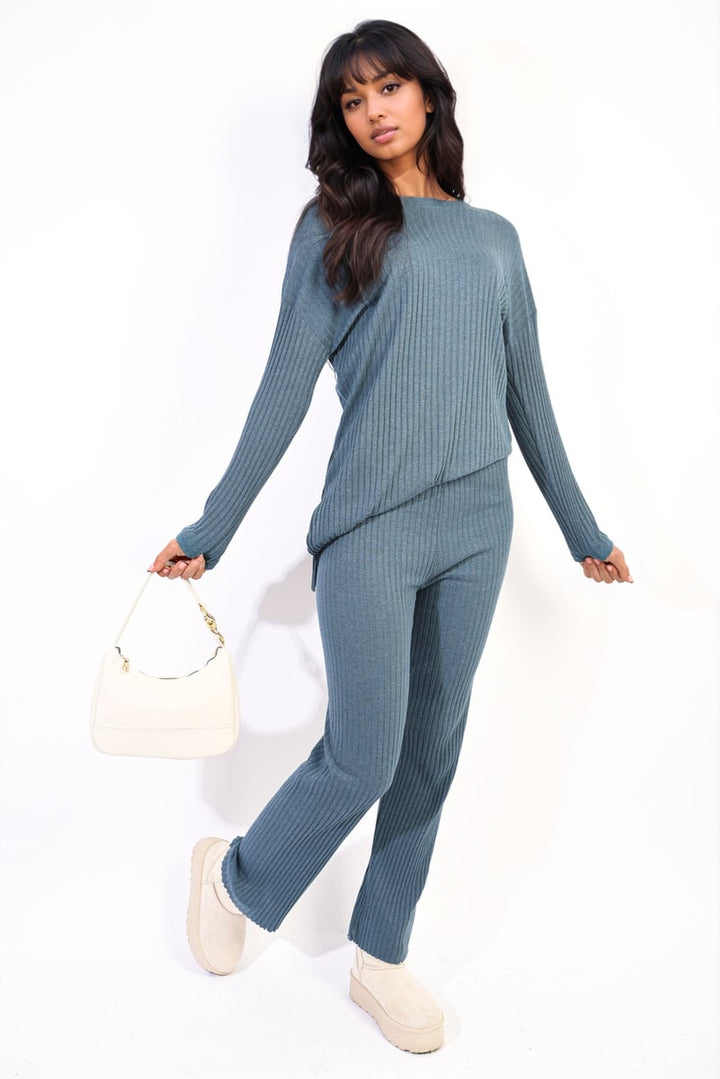 Woman wearing Annalise Knitted Top and Trouser Co-ord Set, paired with white shoes and holding a white purse, embodying casual comfort and style.