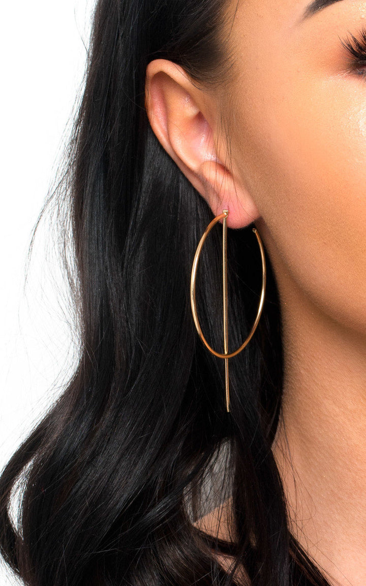 Close-up of a woman's ear showcasing the Statement Hoop Earrings with gold plating and a delicate post backing design.