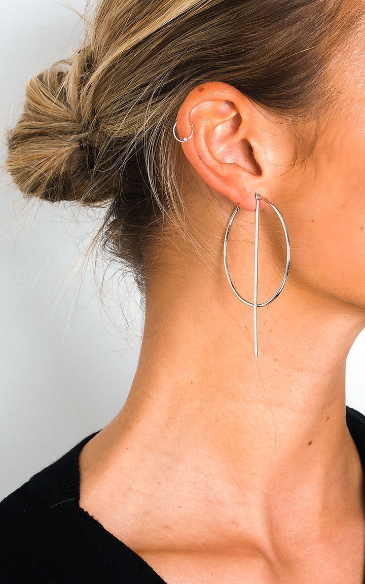 Statement Hoop Earrings featuring a delicate silver-plated design with post backing, worn by a woman in a black shirt, highlighting elegant simplicity.