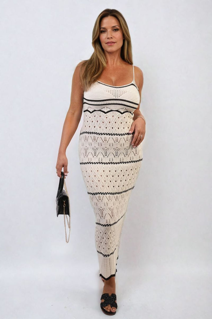 Woman modeling the Strappy Long Knitted Stripe Cami Dress, featuring a flowing silhouette and striking stripe pattern, perfect for stylish holiday occasions.