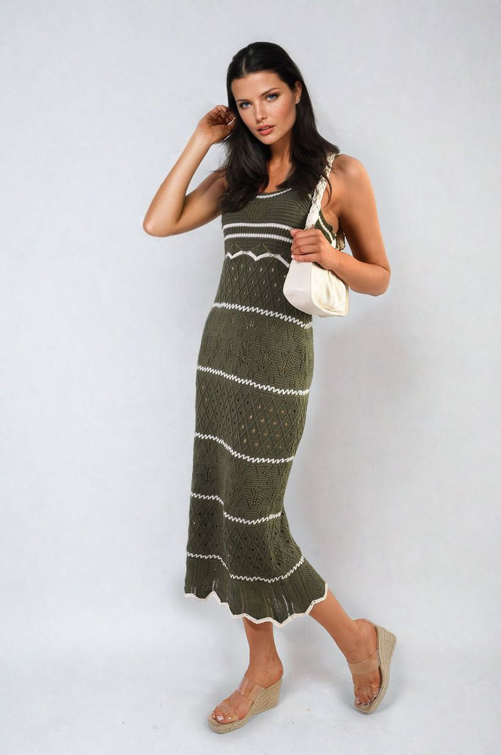 Woman in a Strappy Long Knitted Stripe Cami Dress holds a purse, showcasing its elegant design and comfortable fit, ideal for stylish holiday occasions.