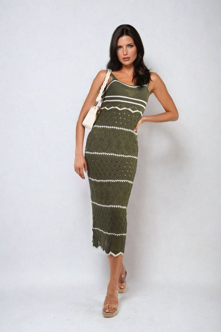 Woman in a Strappy Long Knitted Stripe Cami Dress holding a white purse, showcasing its elegant, flowing silhouette and modern stripe pattern.