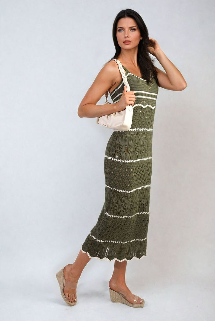 Woman modeling a Strappy Long Knitted Stripe Cami Dress, holding a purse, showcasing its elegant, flowing silhouette and modern strappy design.