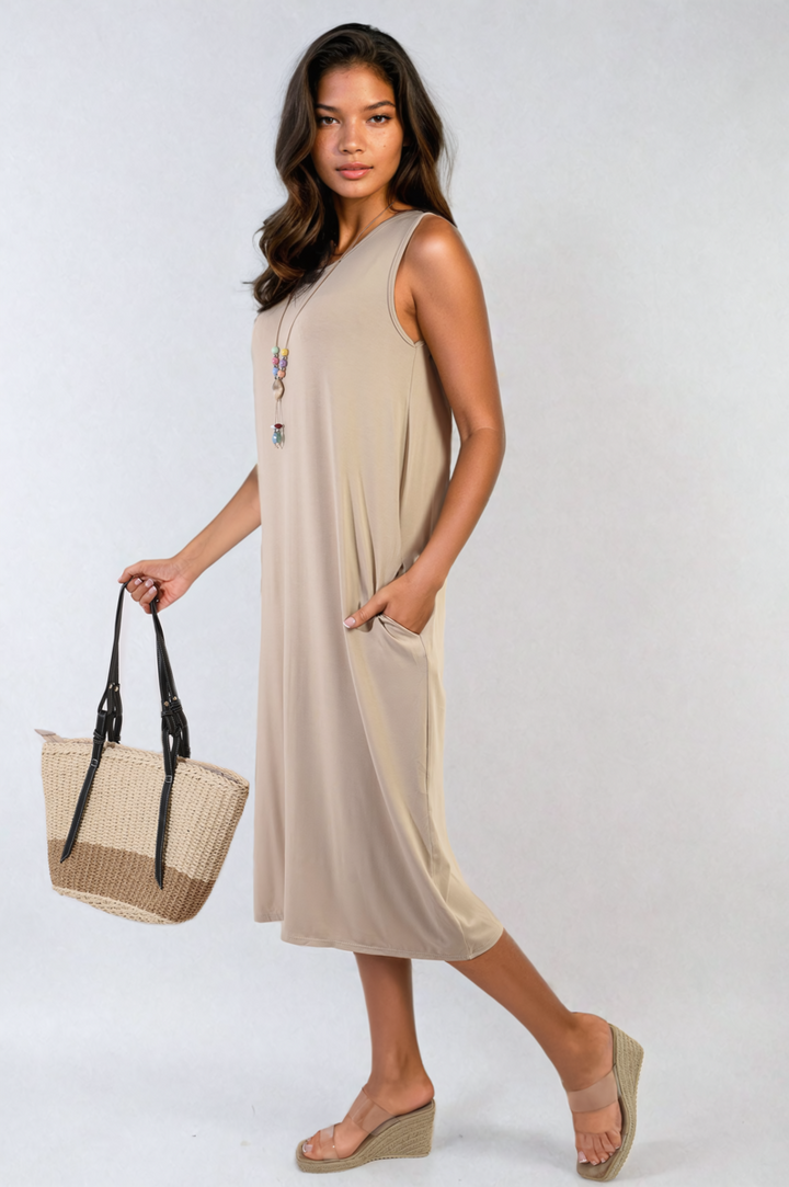 Woman in a sleeveless slit midi dress with side pockets, holding a handbag, showcasing a chic and practical style from Holiday-clothes.co.uk.