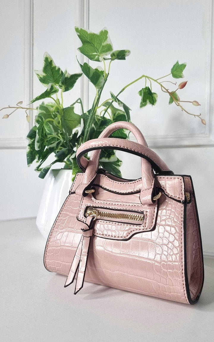 Croc Print Handbag with chic faux leather design, displayed next to a plant, highlighting its stylish appeal and spacious interior for essentials.