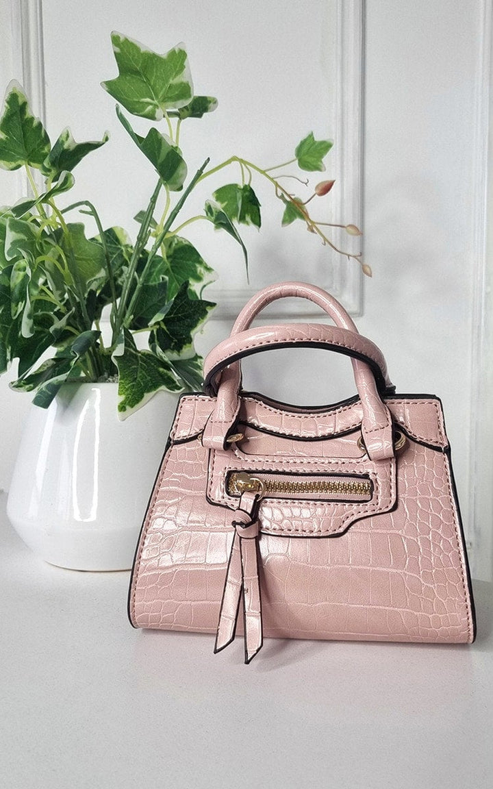 Croc Print Handbag with chic faux leather design, displayed next to a potted plant, showcasing stylish elegance and functionality for any occasion.