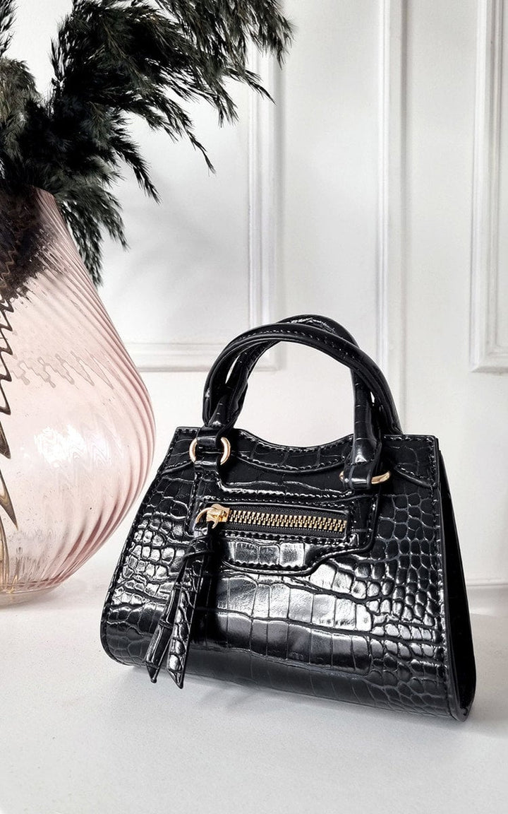 Croc Print Handbag with gold zippers, displayed next to a vase, ideal for organizing essentials stylishly.