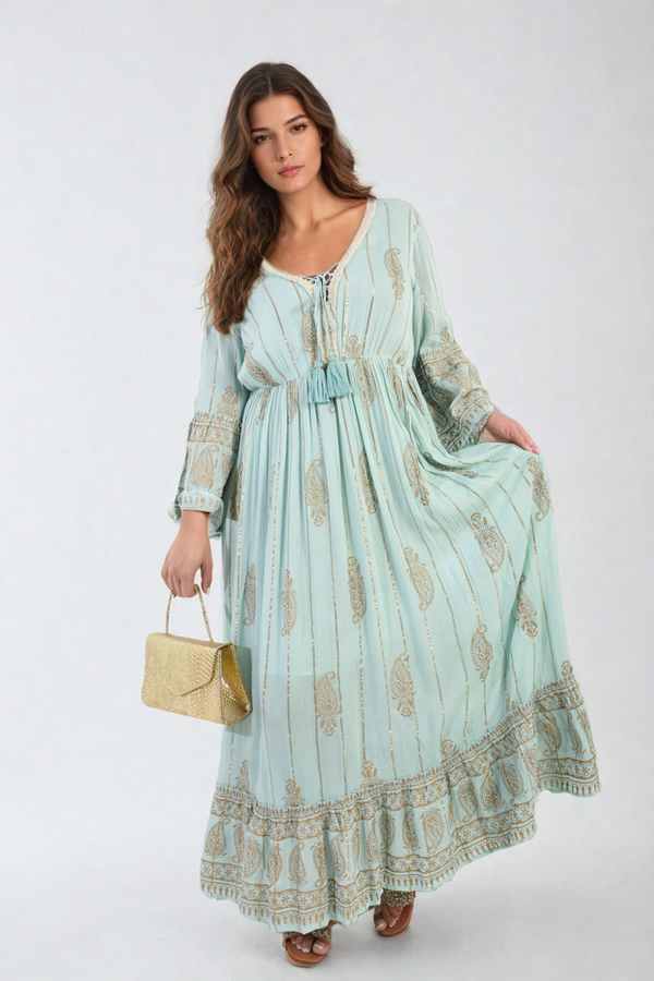 Woman in an Embellished Boho Flounce Sleeve Maxi Dress holding a gold purse, showcasing the dress's elegant flow and detailed embellishments.