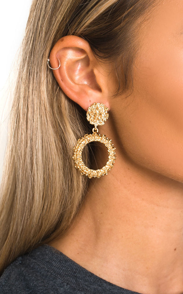 Close-up of a woman's ear wearing Statement Vintage Earrings with a raised design and post backing, highlighting their bold, fashion-forward appeal.