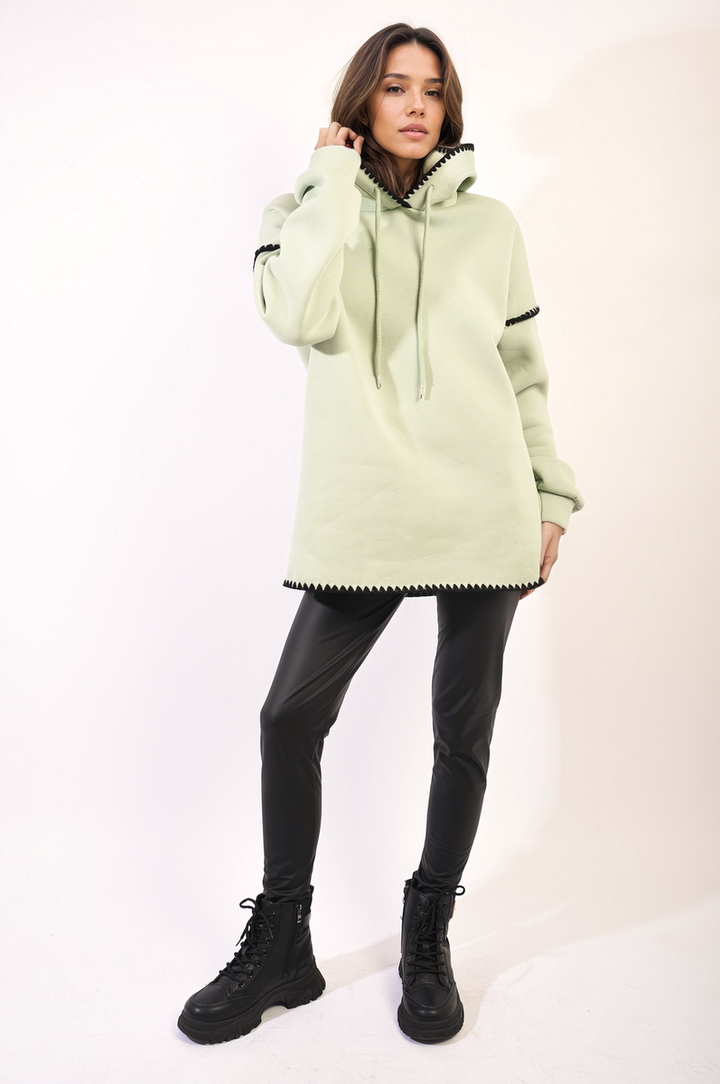 Woman wearing the Bella Blanket Stitch Knitted Hoodie, showcasing its cozy knit design and blanket stitch detailing for a stylish, versatile winter look.