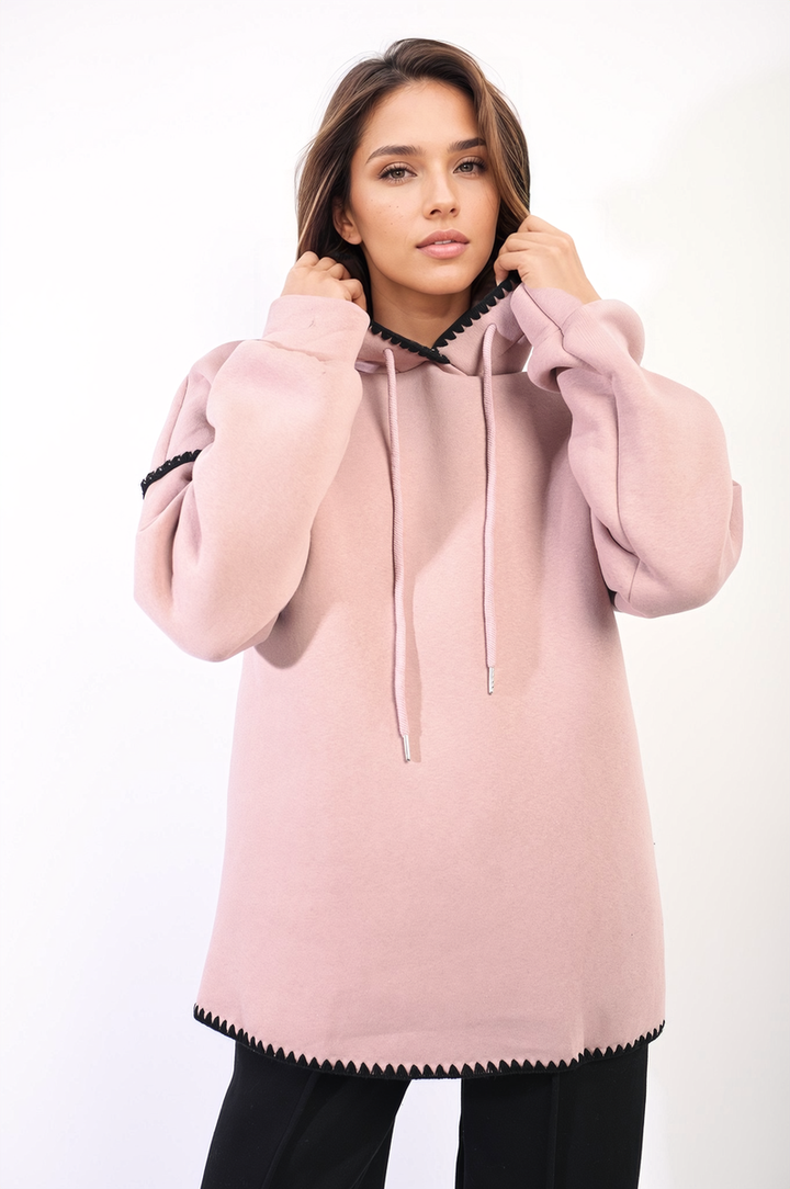 Woman wearing Bella Blanket Stitch Knitted Hoodie, showcasing its cozy knit design and unique blanket stitch detailing, perfect for casual outings or lounging.