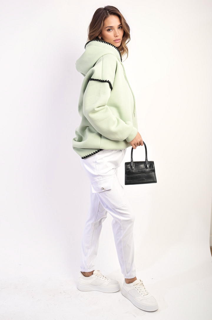 Woman wearing Janelle Drawstring Waist Cargo Joggers, showcasing their stylish fit and practicality with cargo pockets, paired with a black purse and white sneakers.