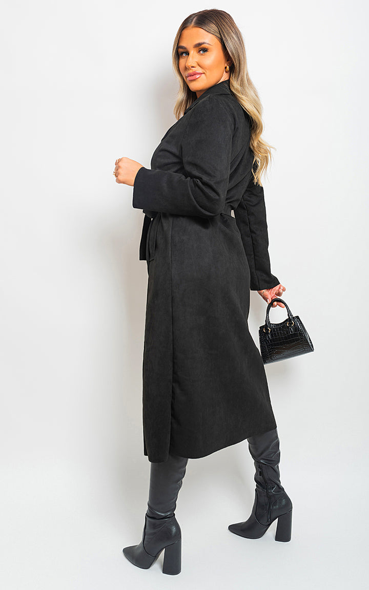 Woman wearing a black Open Front Lapel Neck Longline Trench Coat, holding a purse, showcasing chic outerwear style with boots.