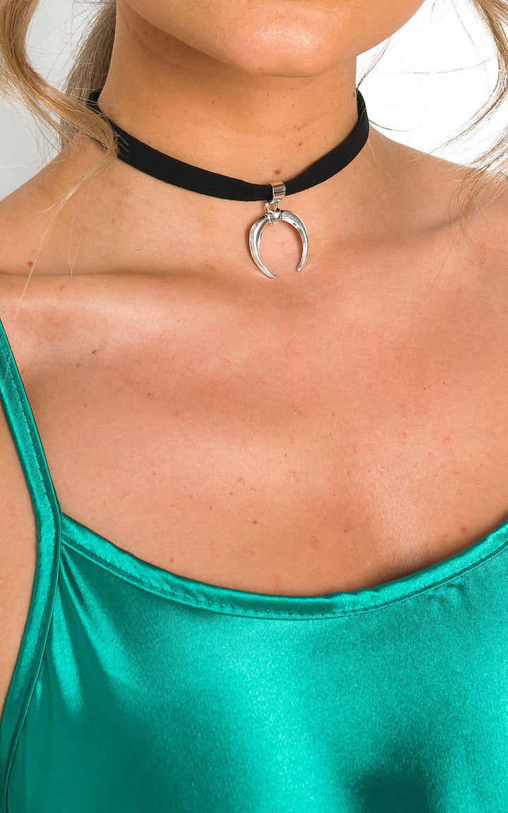 Woman wearing the 'BENNY' Choker, a suede necklace with a silver horseshoe charm, highlighting its fashionable, minimalist design.