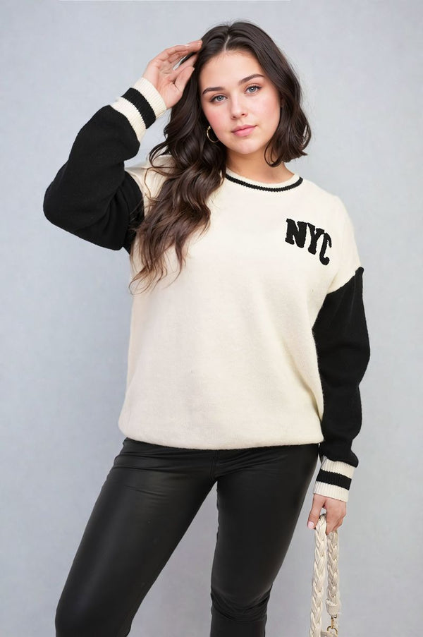 Woman wearing the Brooklyn NYC Print Long Sleeve Knitted Jumper, showcasing urban style with its distinctive print and cozy design. Ideal for casual streetwear.