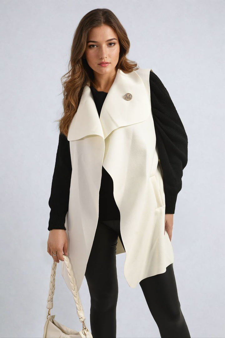 Woman wearing a Wide Lapel Sleeveless Belted Jacket, showcasing its chic design and flattering belted waist, perfect for layering and enhancing your silhouette.