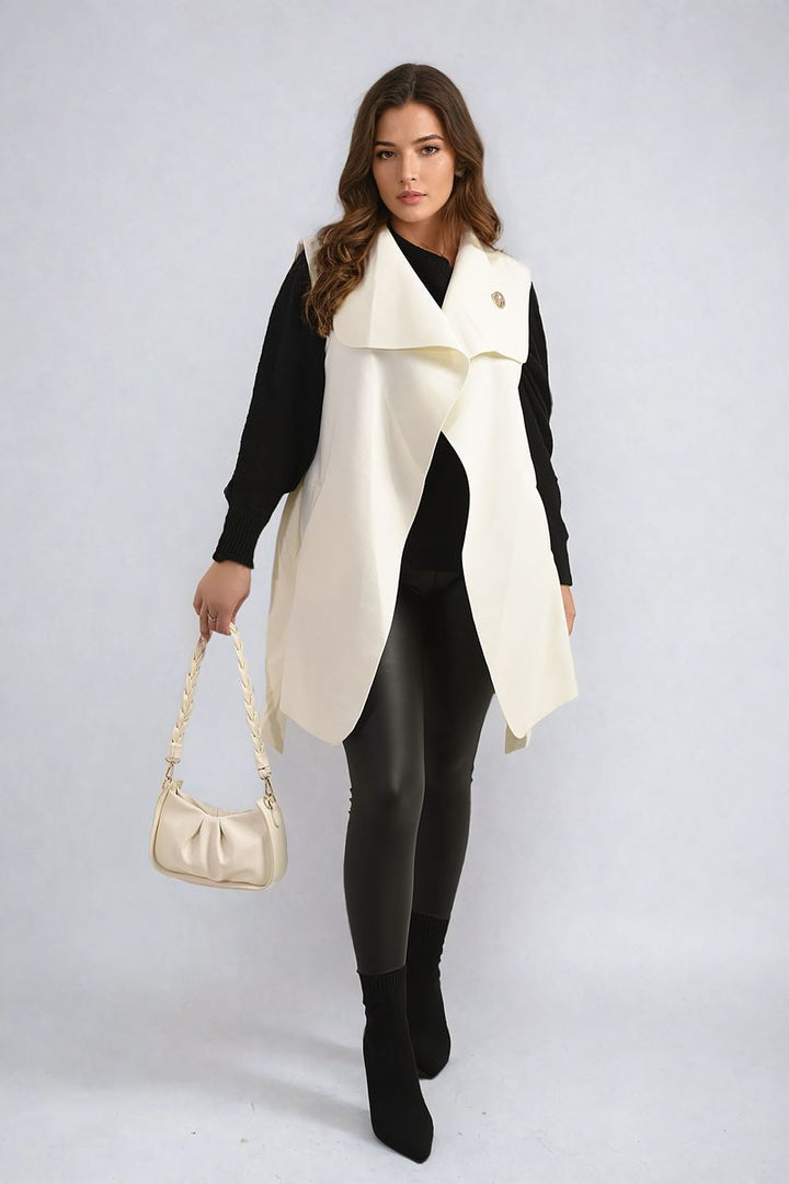 Wide Lapel Sleeveless Belted Jacket showcased by a woman, paired with a stylish white purse, emphasizing a chic, layered look perfect for versatile fashion.