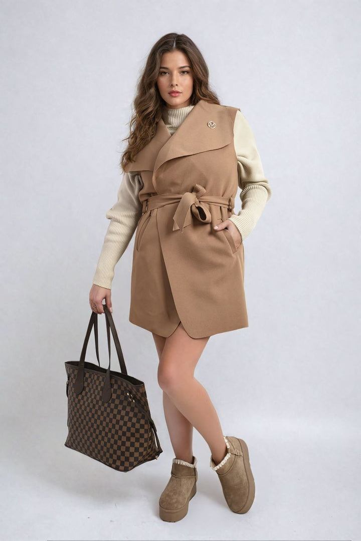 Woman in brown dress models the Camila Wide Lapel Sleeveless Belted Jacket, showcasing its chic silhouette and stylish design, holding a checkered handbag.