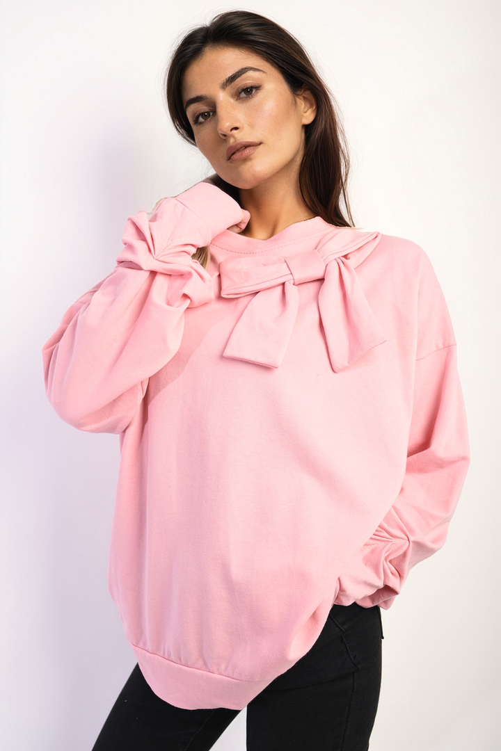 Woman wearing the Carina Long Sleeve Bow Detail Jumper, demonstrating its elegant bow sleeve design, ideal for stylish comfort in colder months.